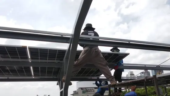 ช่างกำลังติดตั้งแผงบนโครงสร้าง